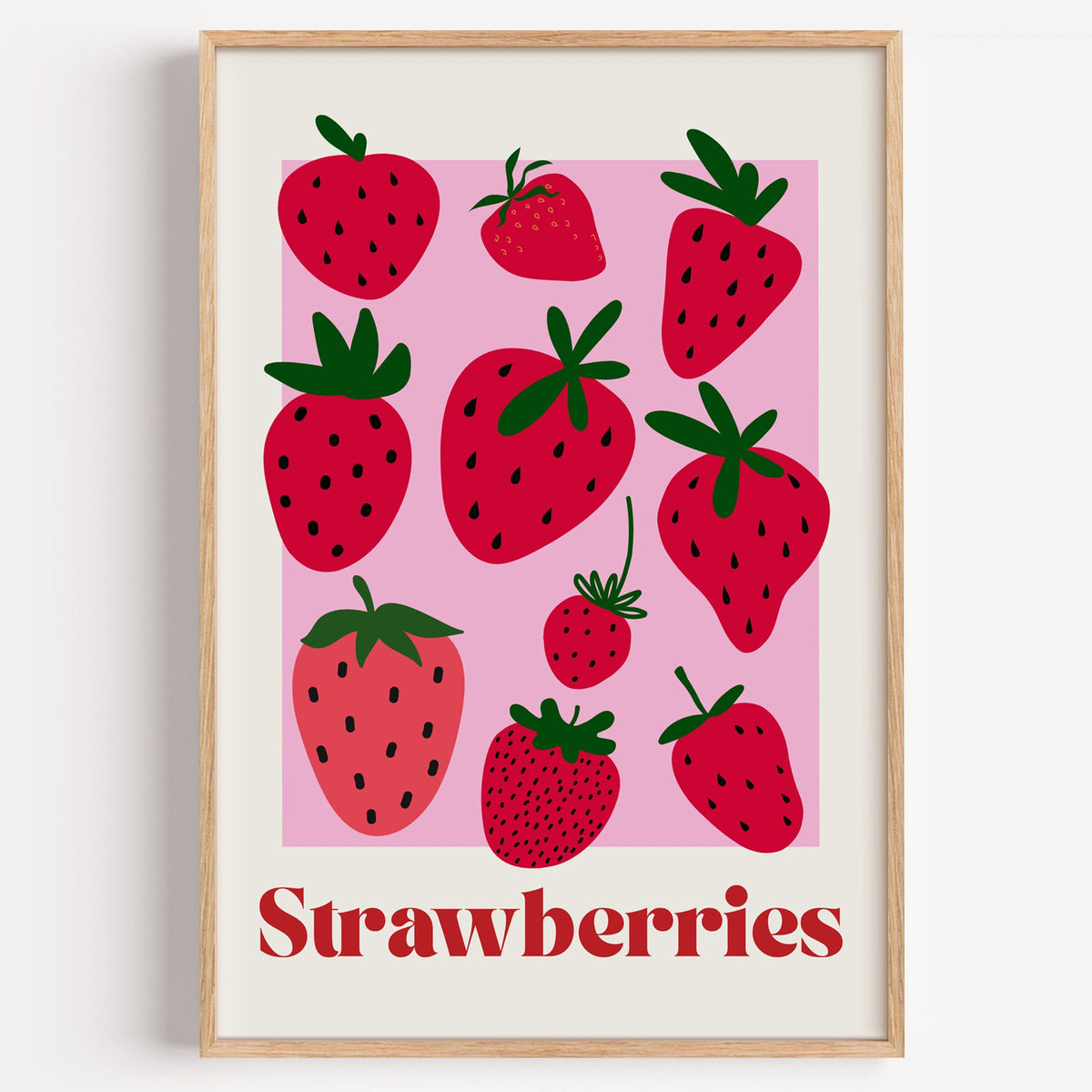 Strawberries bold serif pink panel berry print in a light oak frame on a plain white wall