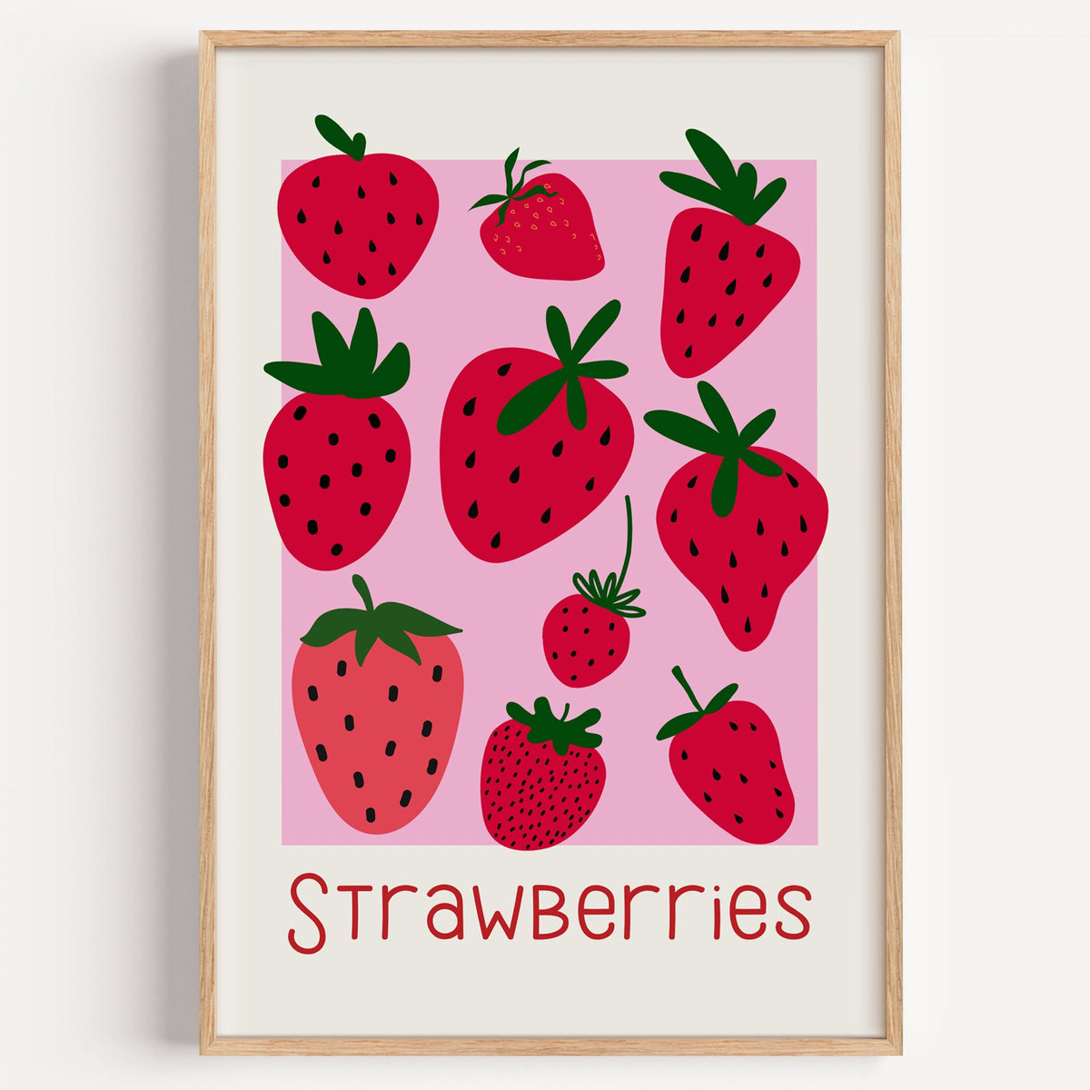 Strawberries thin lettering pink panel berry print in a light oak frame on a plain white wall