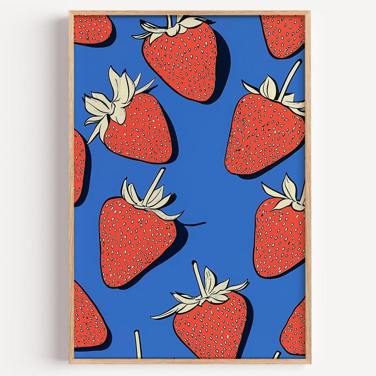 Strawberry pattern print in a light oak frame on a plain white wall
