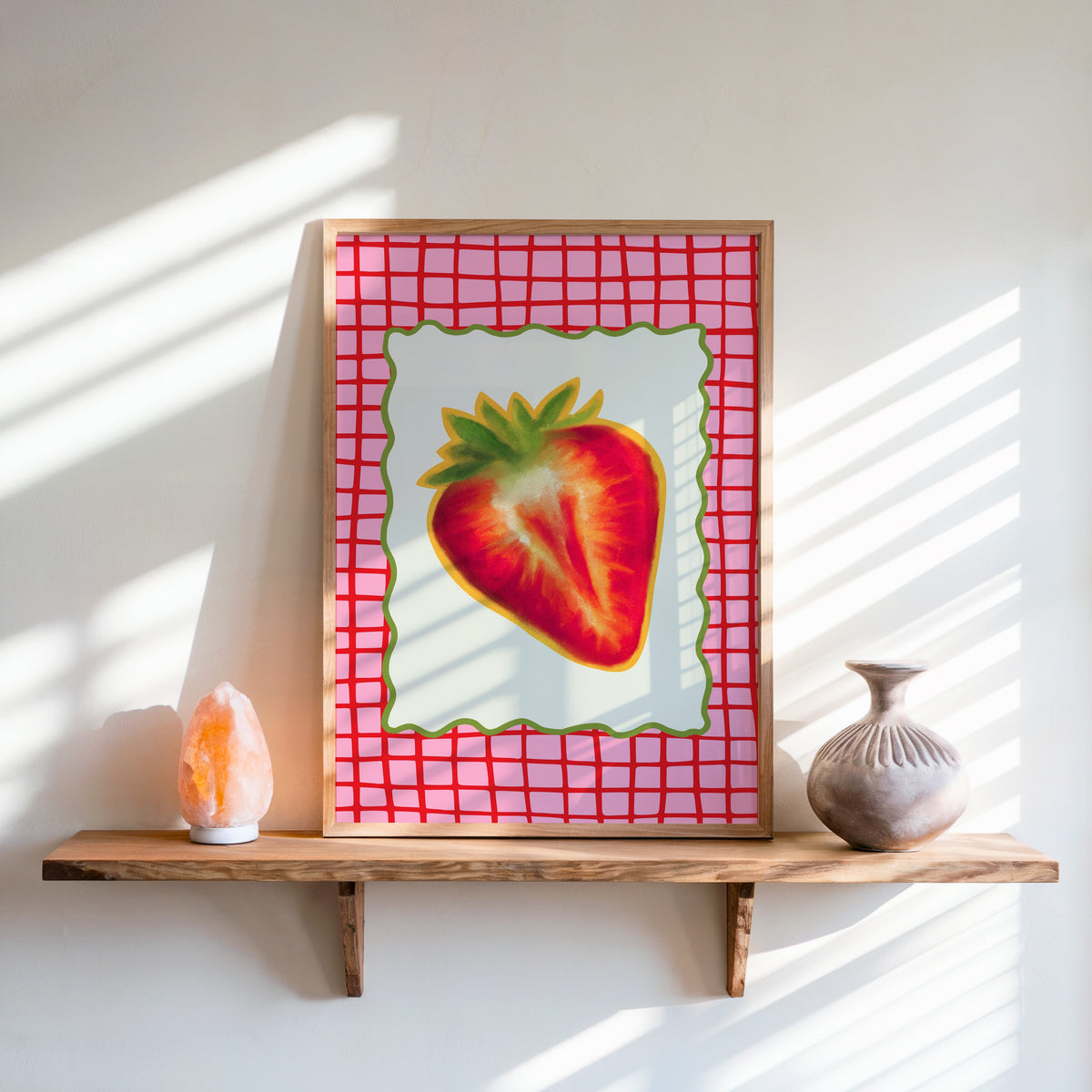 Strawberry red grid print in an oak frame on a live-edge shelf beside a salt lamp