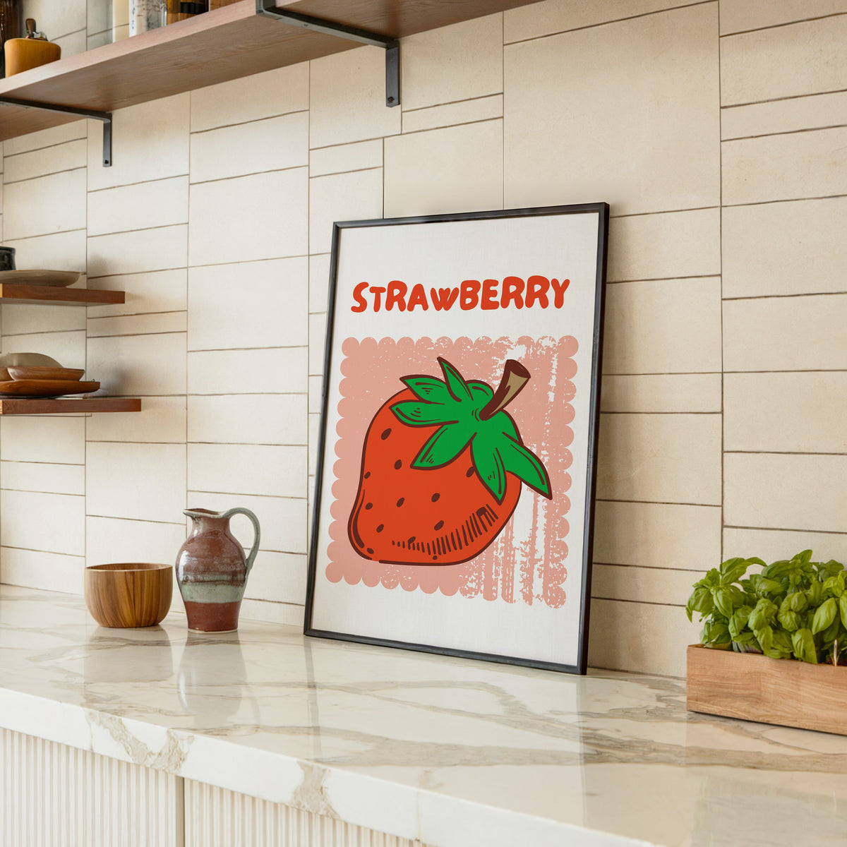 Strawberry scallop print in a black frame leaning on a marble counter in a tiled kitchen