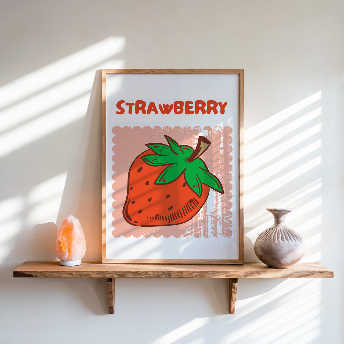 Strawberry scallop print in an oak frame on a live-edge shelf beside a salt lamp