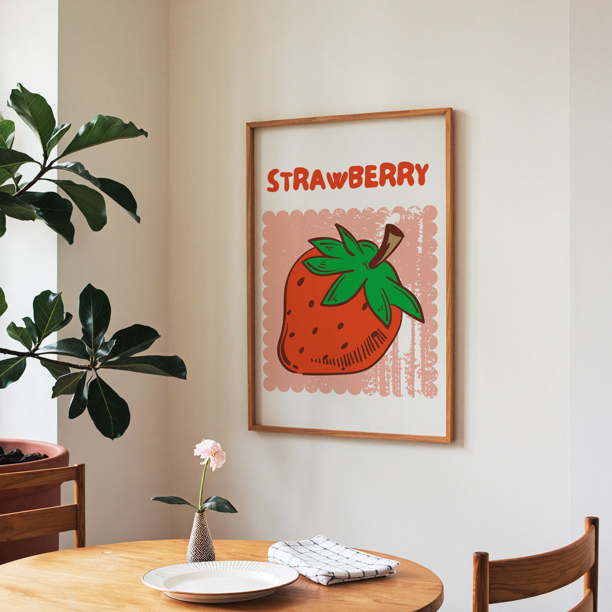 Strawberry scallop print in a walnut frame above a round table beside a fiddle-leaf fig
