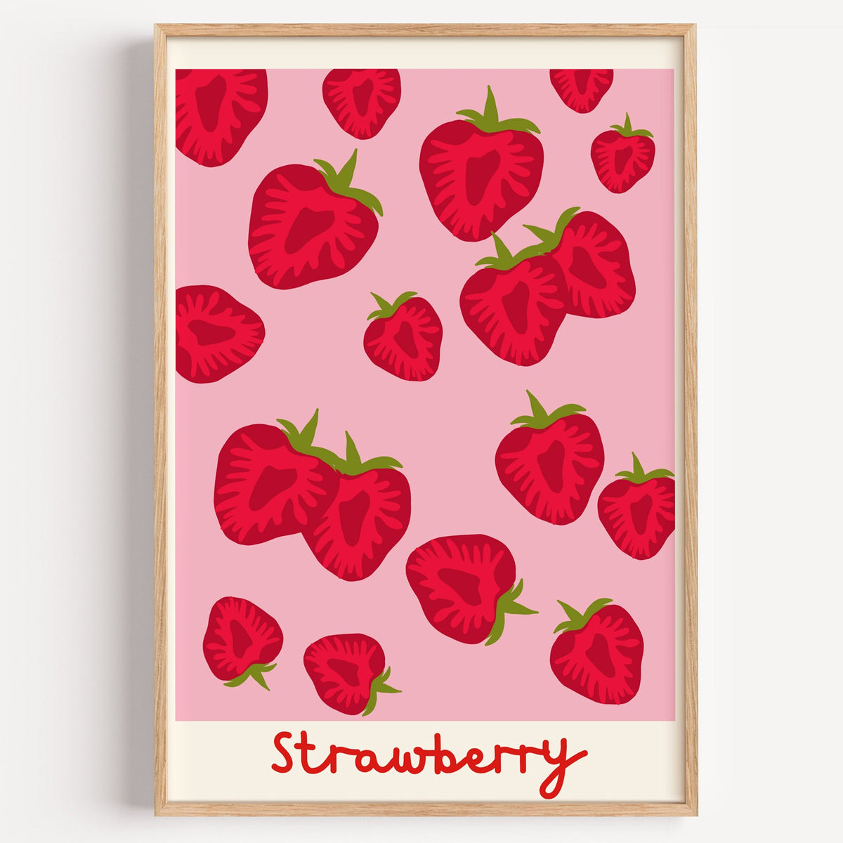 Strawberry scatter print in a light oak frame on a plain white wall