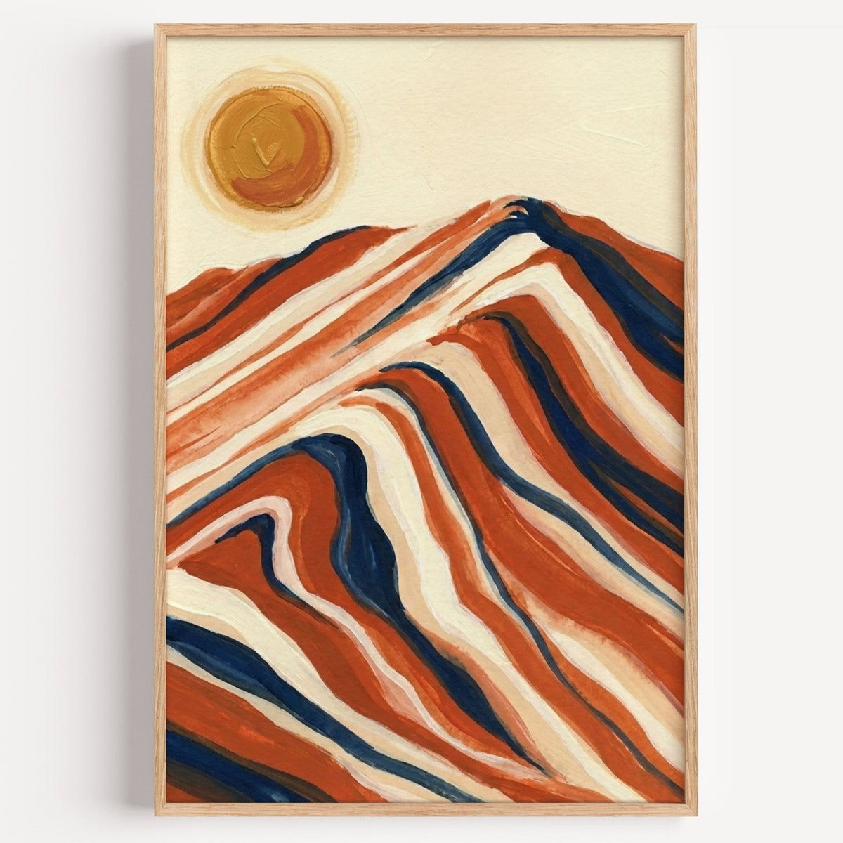 Striped mountain and sun print in a light oak frame on a plain white wall