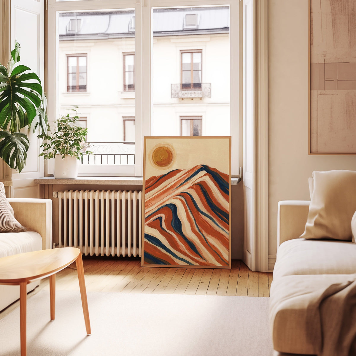 Rust and navy mountain print in an oak frame leaning below tall French windows