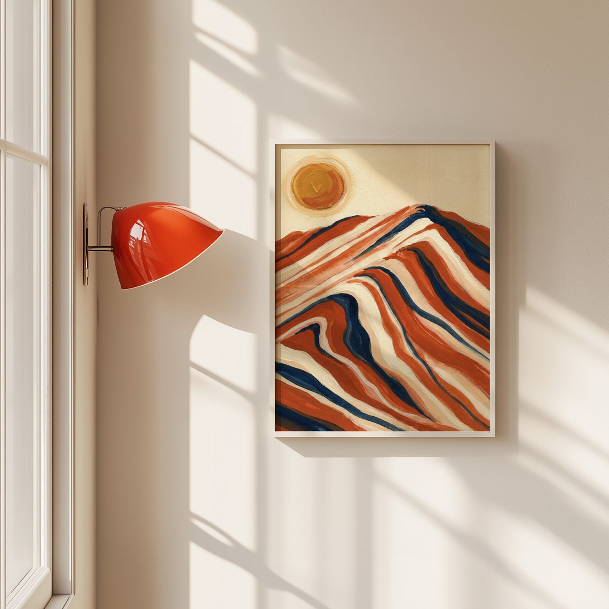 Striped mountain and sun print in a white frame beside a red wall sconce