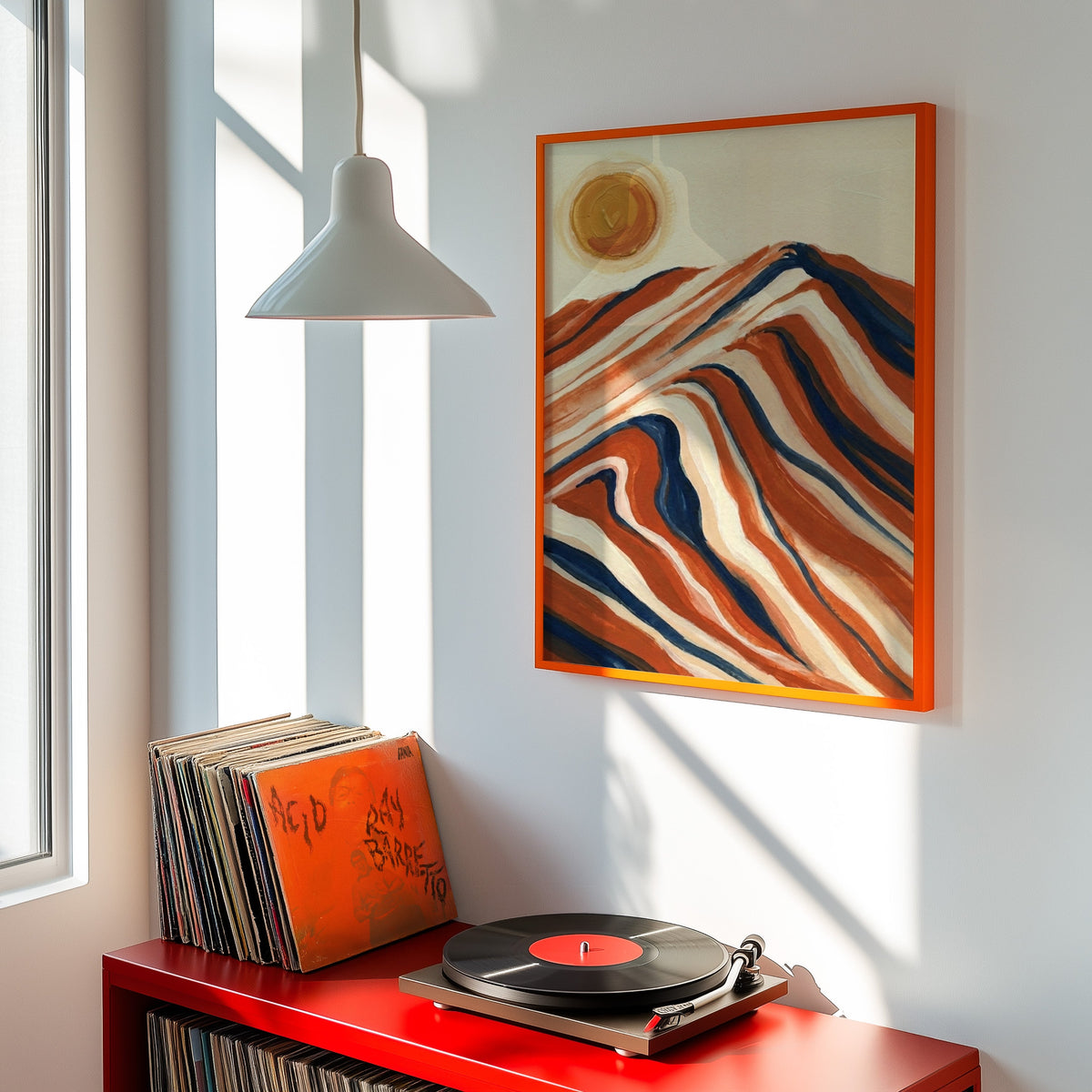 Rust and navy mountain print shown in an orange frame above a red record cabinet and turntable