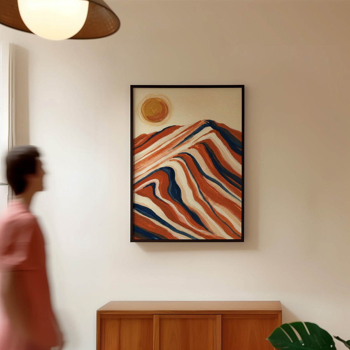 Mid-century mountain print in a black frame in a hallway under a rattan pendant