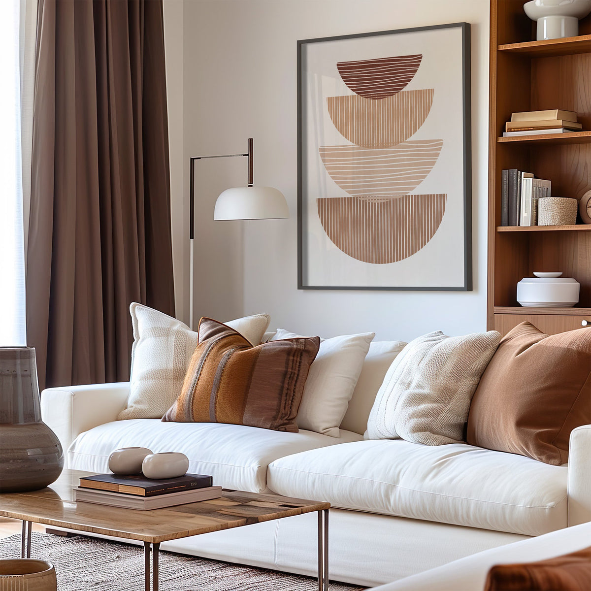 Striped stacked bowls earth tone print in a black frame above a cream sofa with brown striped pillows