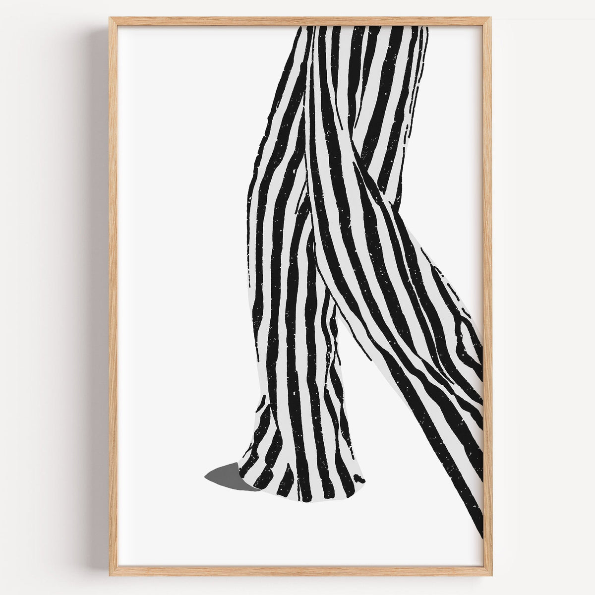 Walking legs in striped trousers graphic print in a light oak frame on a plain white wall