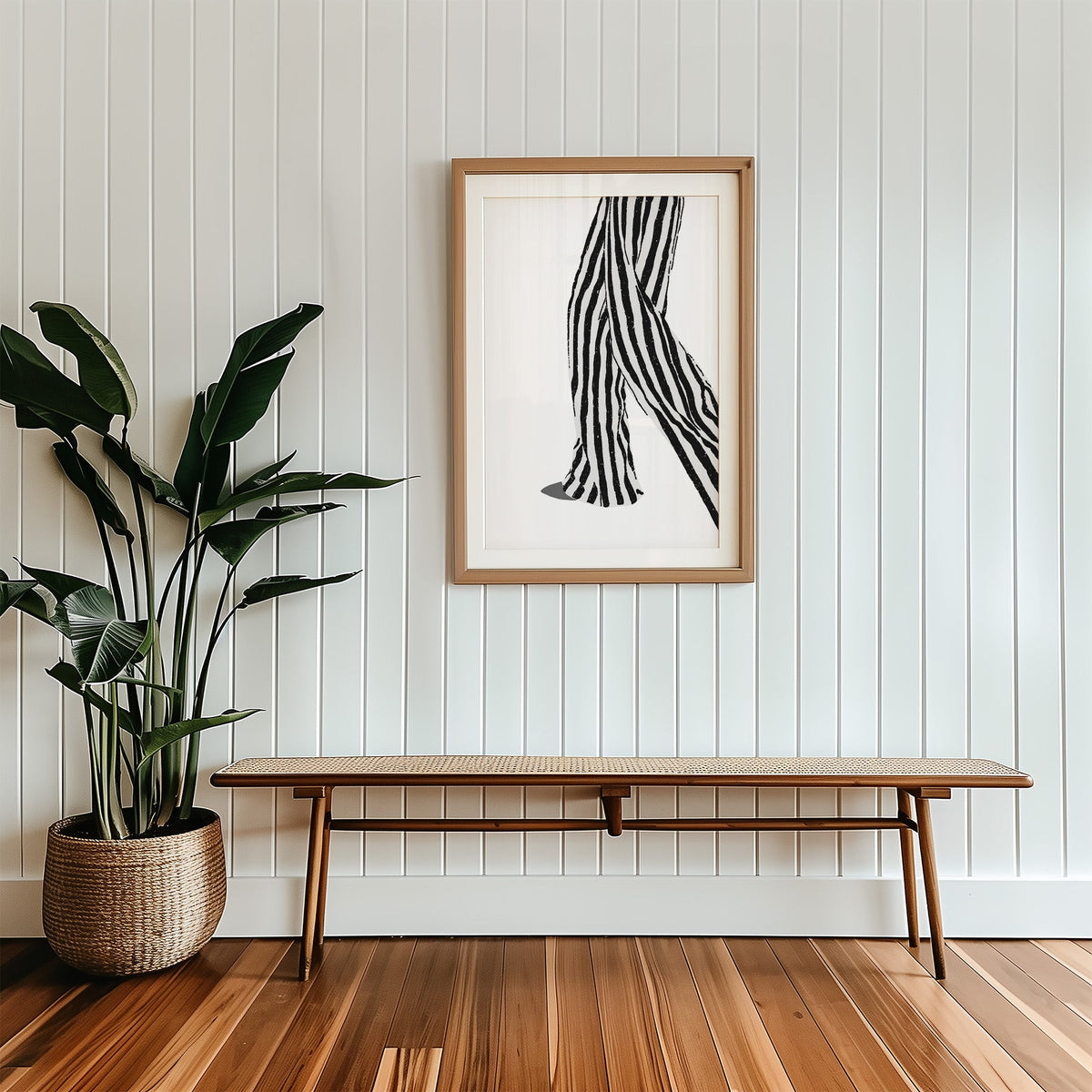 Walking legs in striped trousers graphic print in a wood frame with a white mat above a cane bench