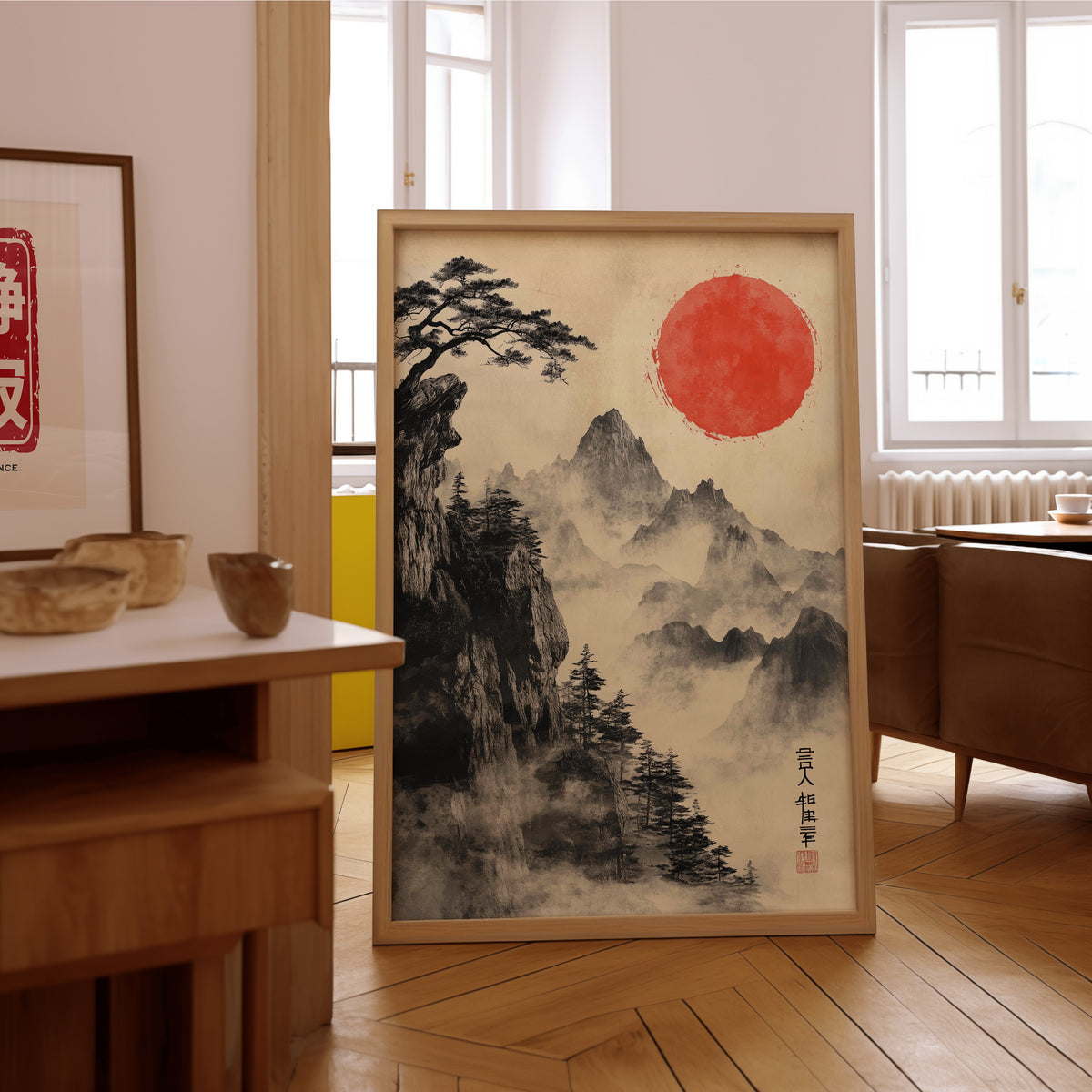 Sumi-e misty mountains and red sun print in an oak frame on the parquet floor of a sunlit living room