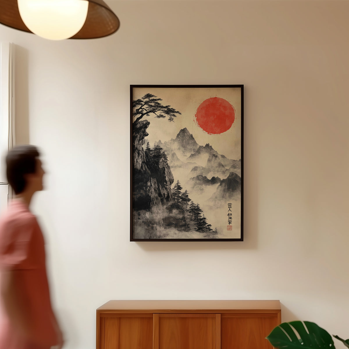 Sumi-e misty mountains and red sun print in a black frame in a hallway under a rattan pendant