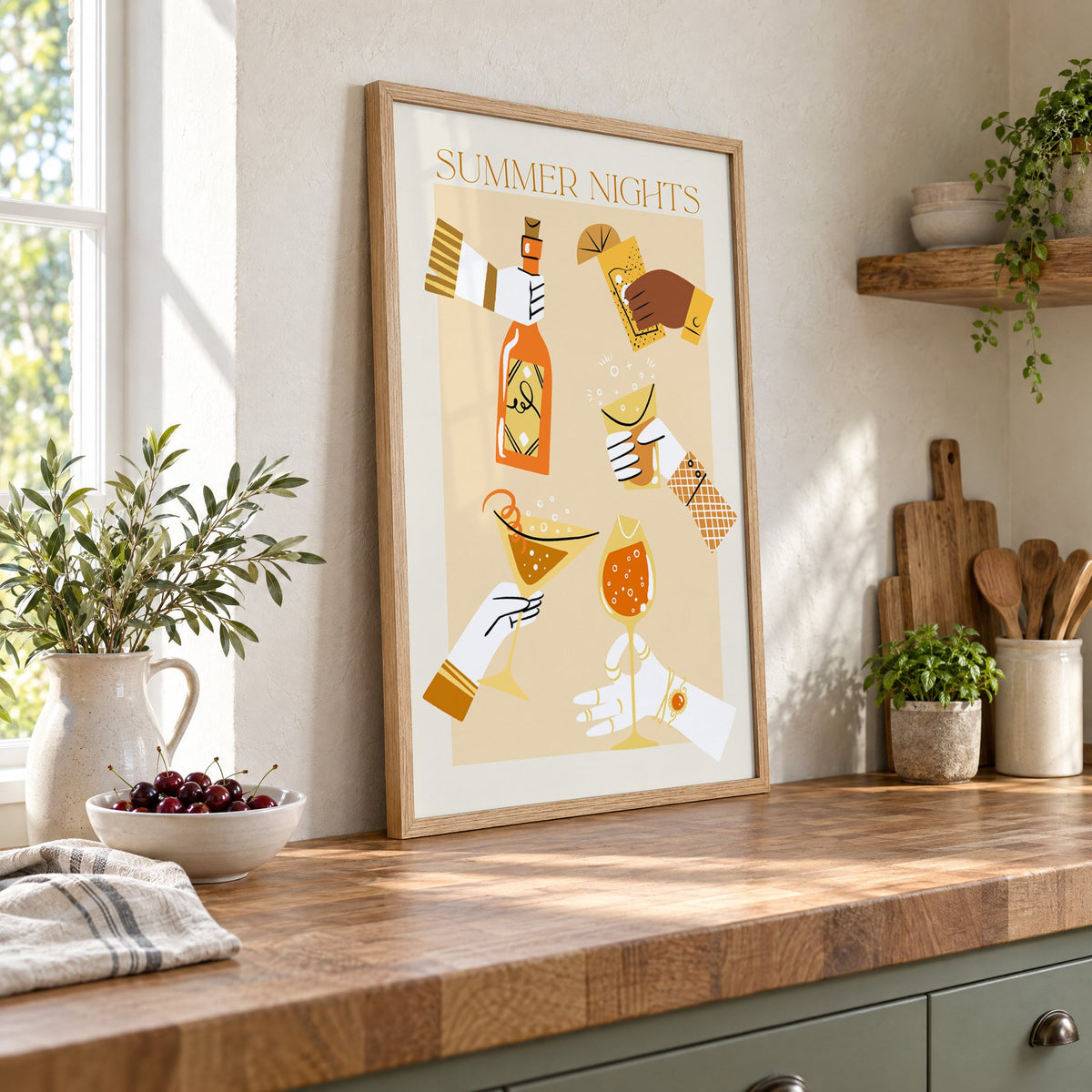 Summer Nights cocktail toast print in an oak frame leaning on a butcher block island beside a bowl of cherries