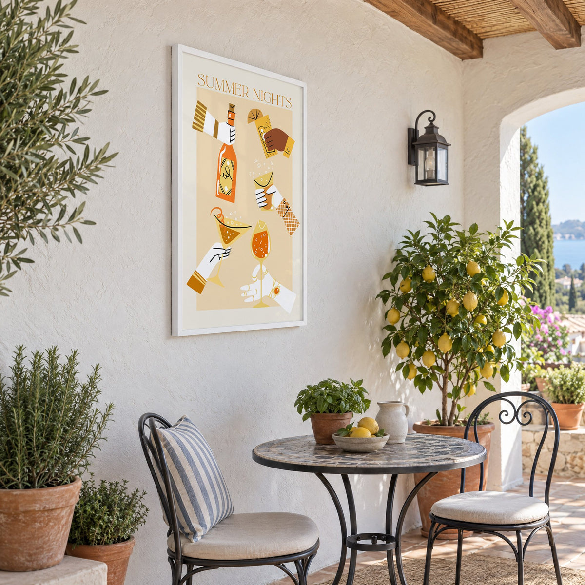 Summer Nights cocktail toast print in a white frame on a sunny patio wall beside a potted lemon tree