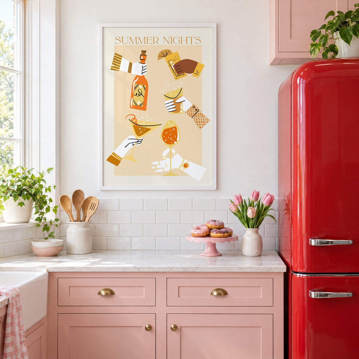 Summer Nights cocktail toast print in a white frame in a pink kitchen beside a red retro fridge