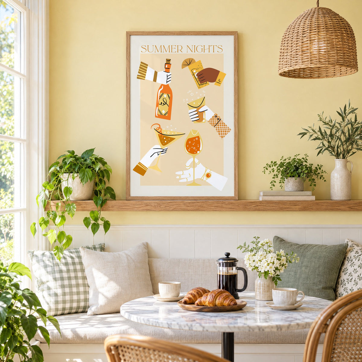 Summer Nights cocktail toast print in an oak frame on a picture ledge above a sunny breakfast nook