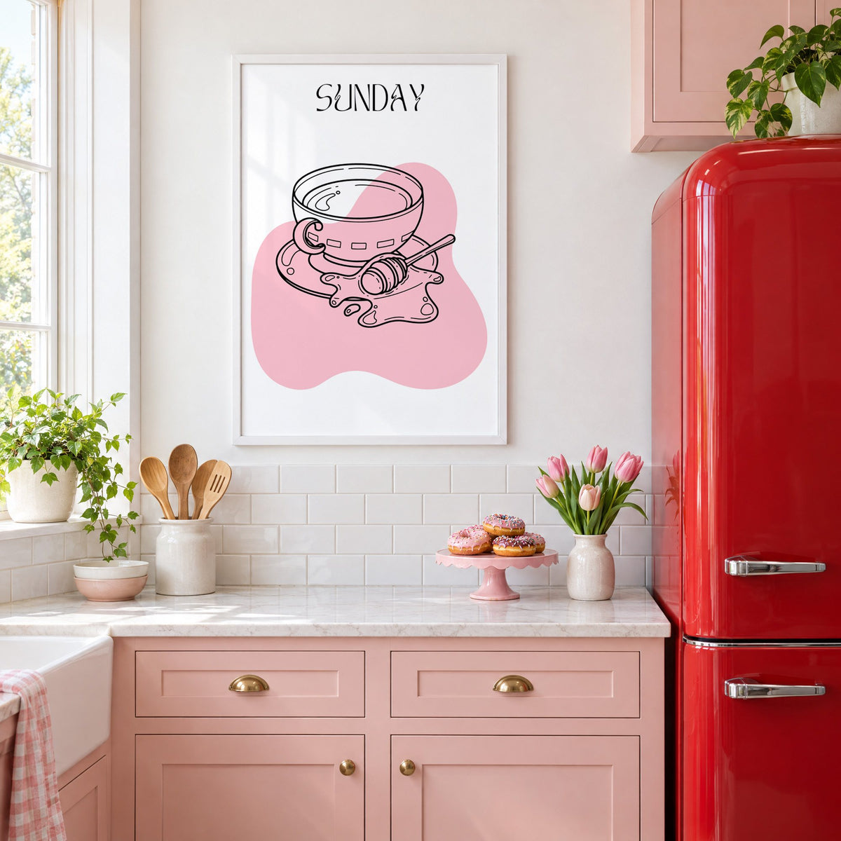 SUNDAY teacup and honey dipper line print in a white frame above pink cabinets beside a red retro fridge