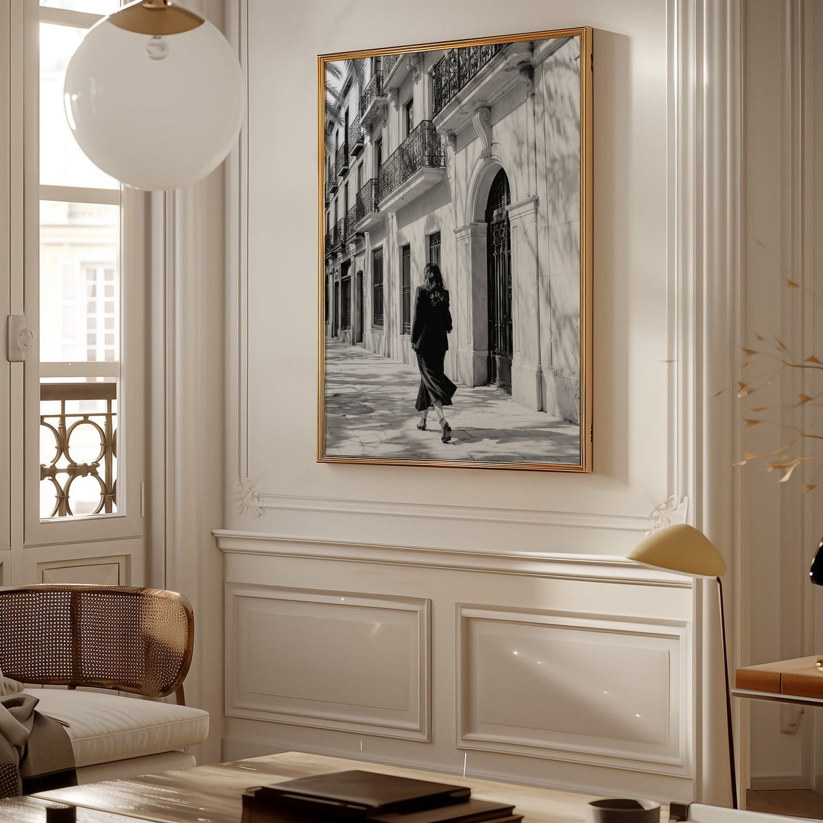 Black and white woman walking under iron balconies print shown in a gold frame in a Parisian paneled living room