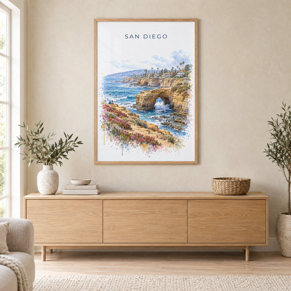 Sunset Cliffs San Diego watercolor print in an oak frame above a light wood sideboard in a Scandinavian living room