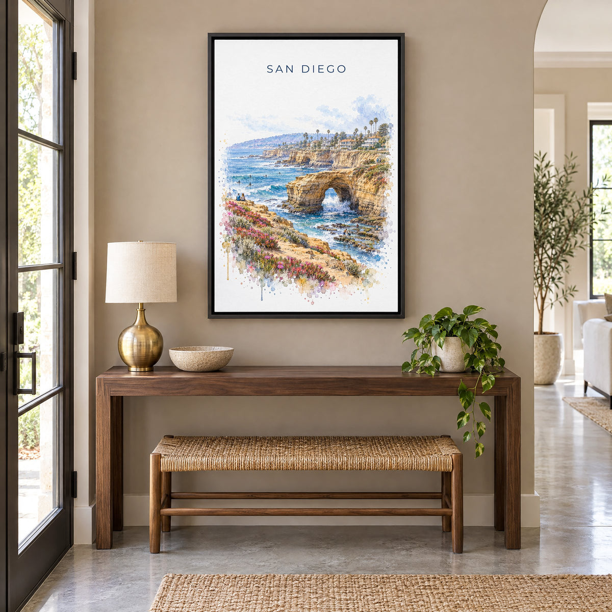Sunset Cliffs San Diego watercolor print as a black floater canvas above a walnut console and woven bench in an entryway