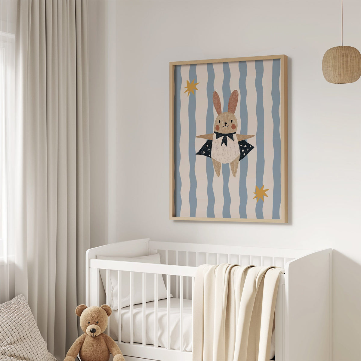 Superhero bunny star cape nursery print in an oak frame above a white crib with a teddy bear
