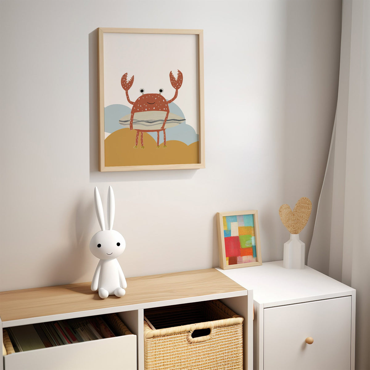 Surfing crab mustard hills nursery print in an oak frame above a kids cubby shelf with a woven basket and bunny lamp