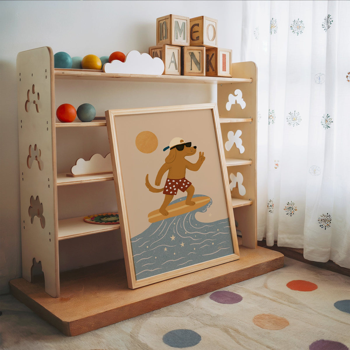 Surfing dog with peace sign nursery print in an oak frame leaning on a toy shelf with wooden letter blocks