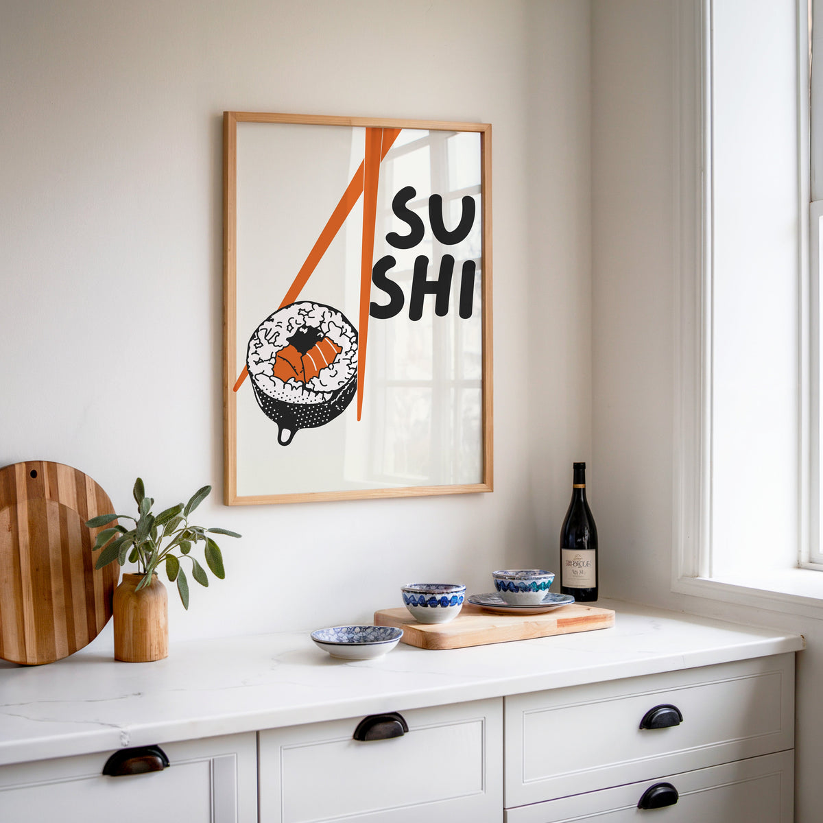 Sushi roll print in an oak frame above a white sideboard with a bottle of wine