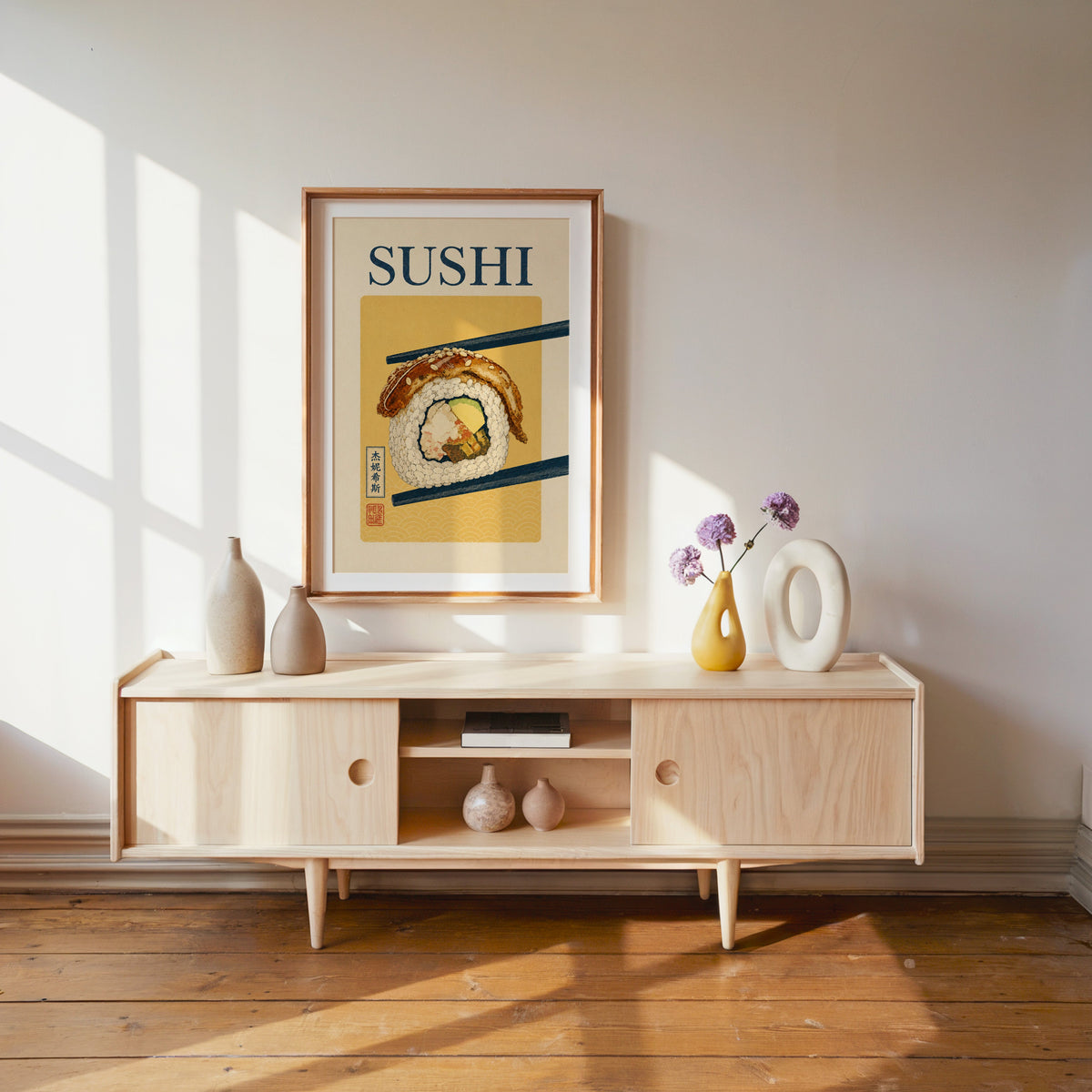 sushi roll in navy chopsticks print shown in a wood frame with a white mat above a pale wood media console