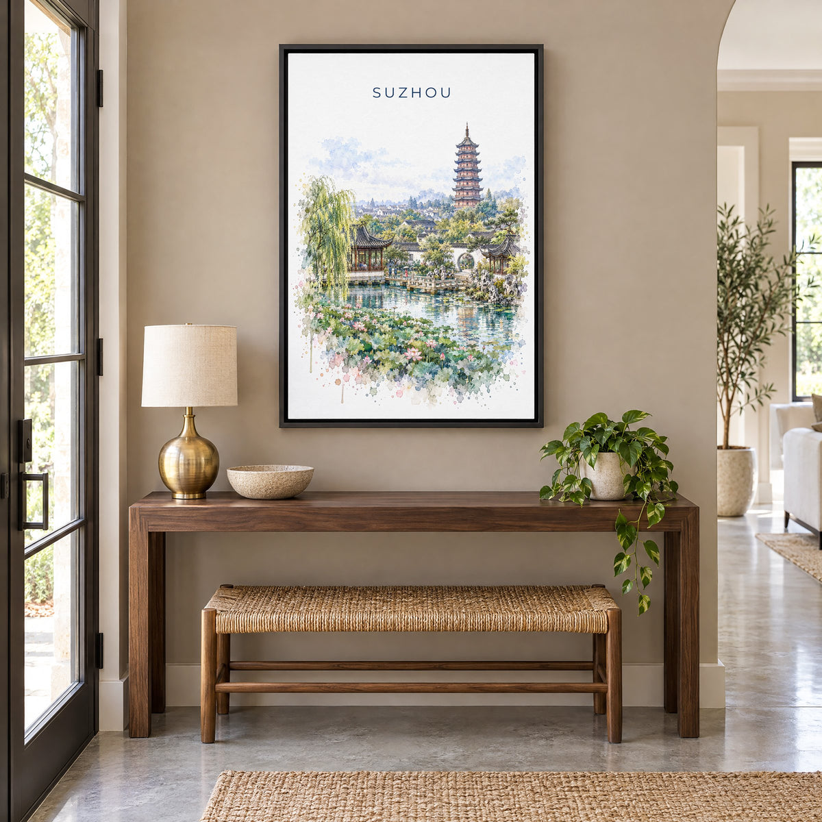 Suzhou watercolor print as a black floater canvas above a walnut console and woven bench in an entryway