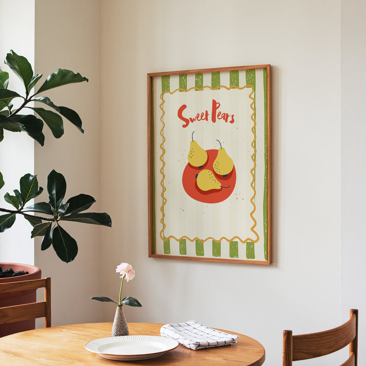 Sweet Pears print in a walnut frame above a round table beside a fiddle-leaf fig
