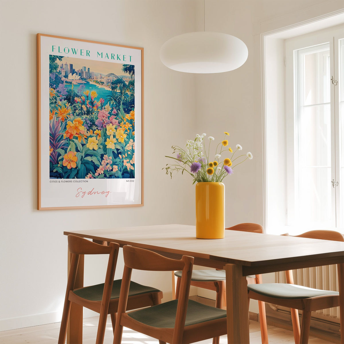 Sydney flower market print in an oak frame above a dining table with a yellow vase and white pendant light