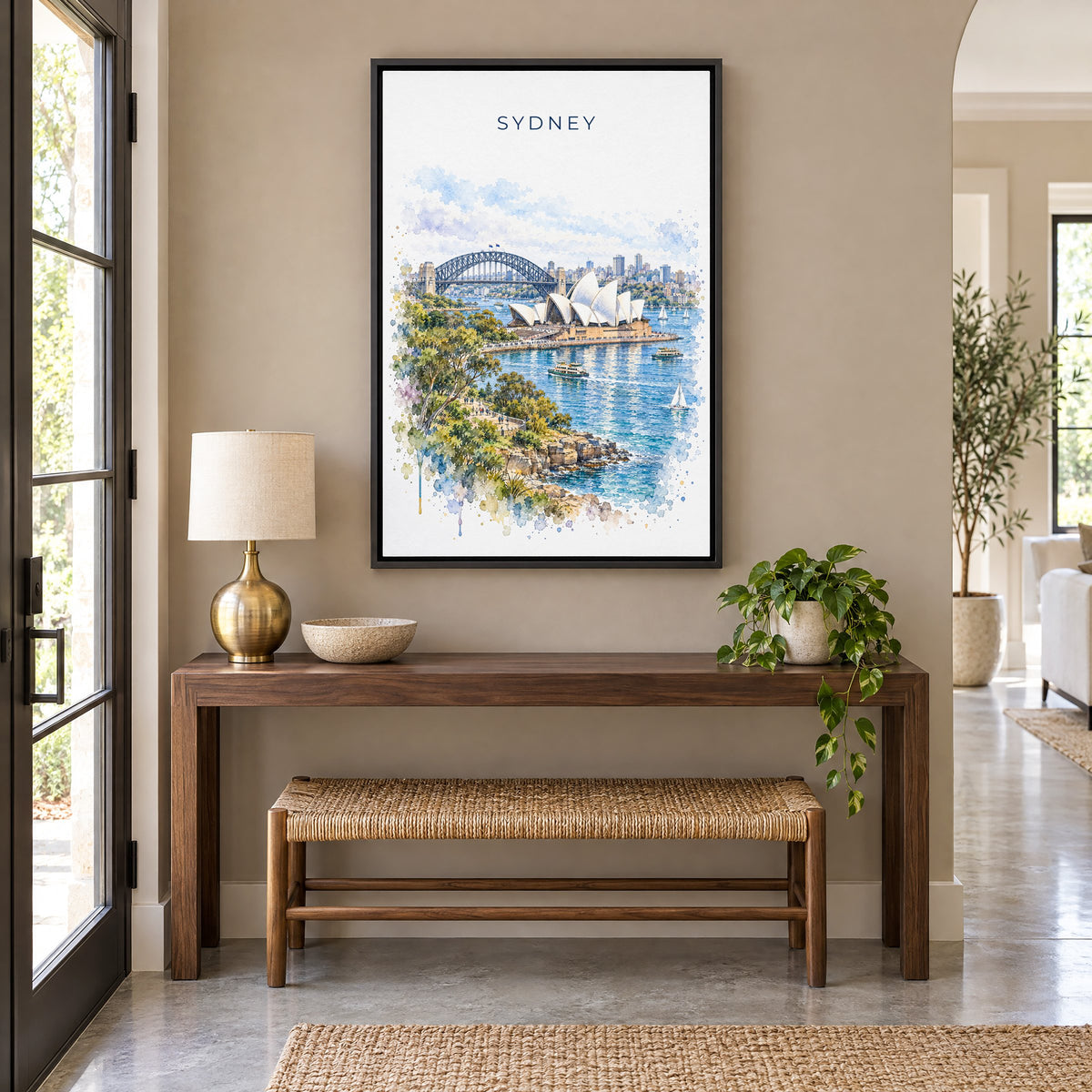 Sydney watercolor print as a black floater canvas above a walnut console and woven bench in an entryway