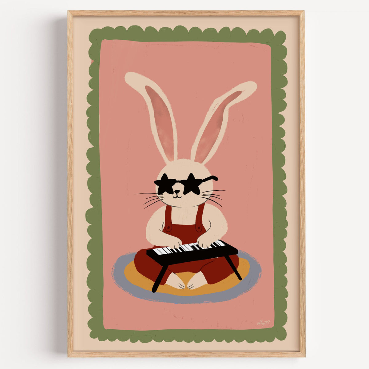 Bunny playing keyboard in star glasses nursery print in a light oak frame on a plain white wall