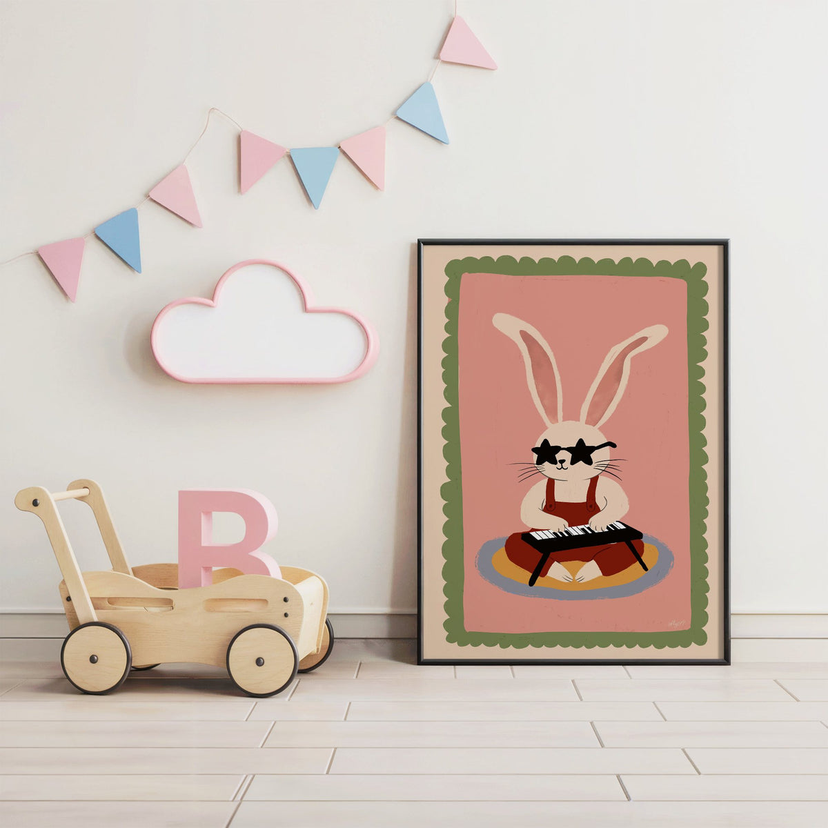 Bunny playing keyboard in star glasses nursery print in a black frame under pastel bunting by a wooden baby walker