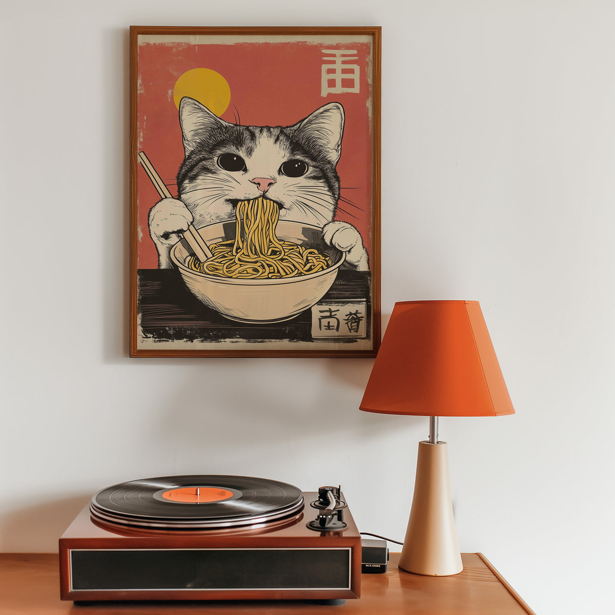 Gray tabby cat eating ramen print in a walnut frame above a sideboard with a record player