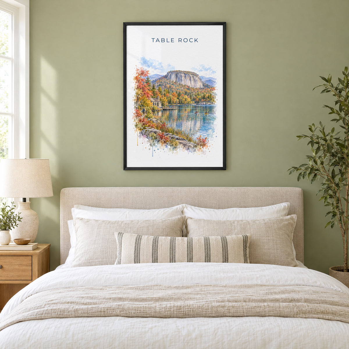 Table Rock State Park watercolor print in a black frame above an upholstered headboard in a sage green bedroom