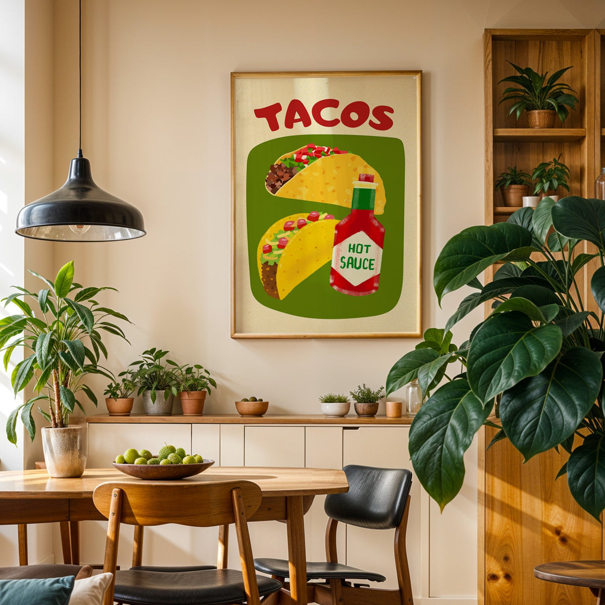Tacos and hot sauce print in an oak frame in a dining room above a plant-lined sideboard