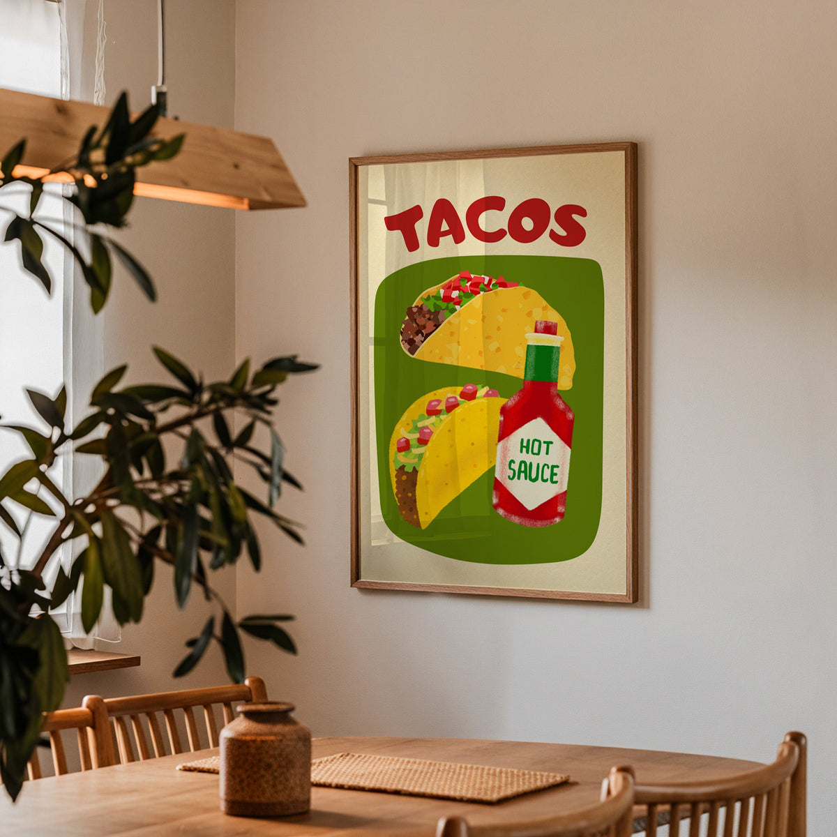 Tacos and hot sauce print in a walnut frame above a dining table with olive branches