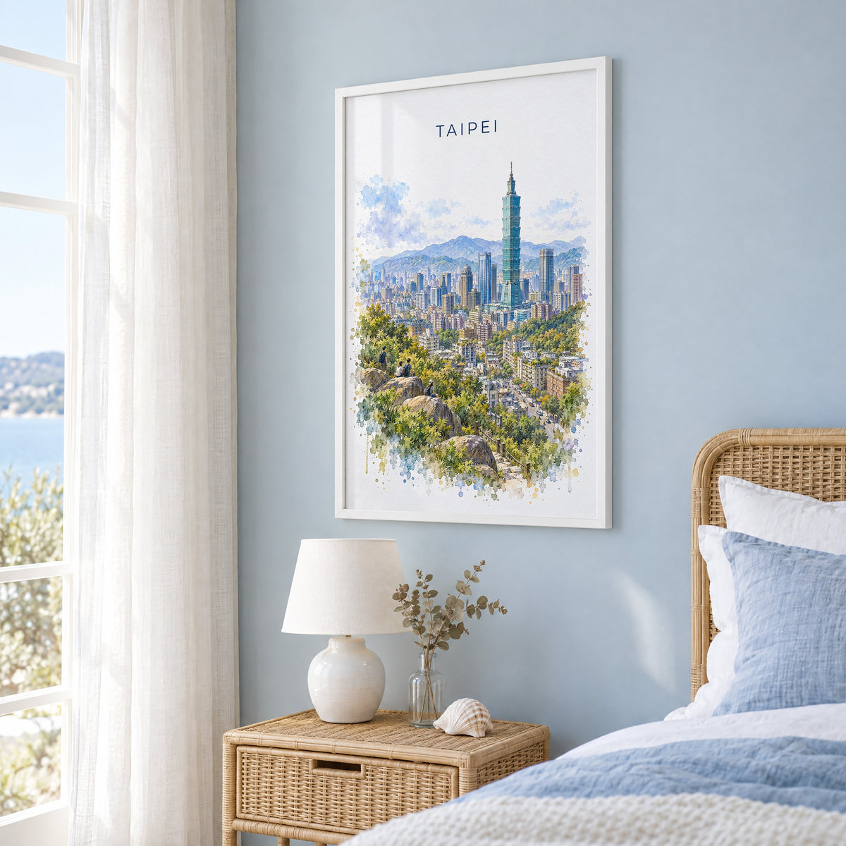 Taipei watercolor print in a white frame on a pale blue wall beside a rattan bed in a coastal bedroom