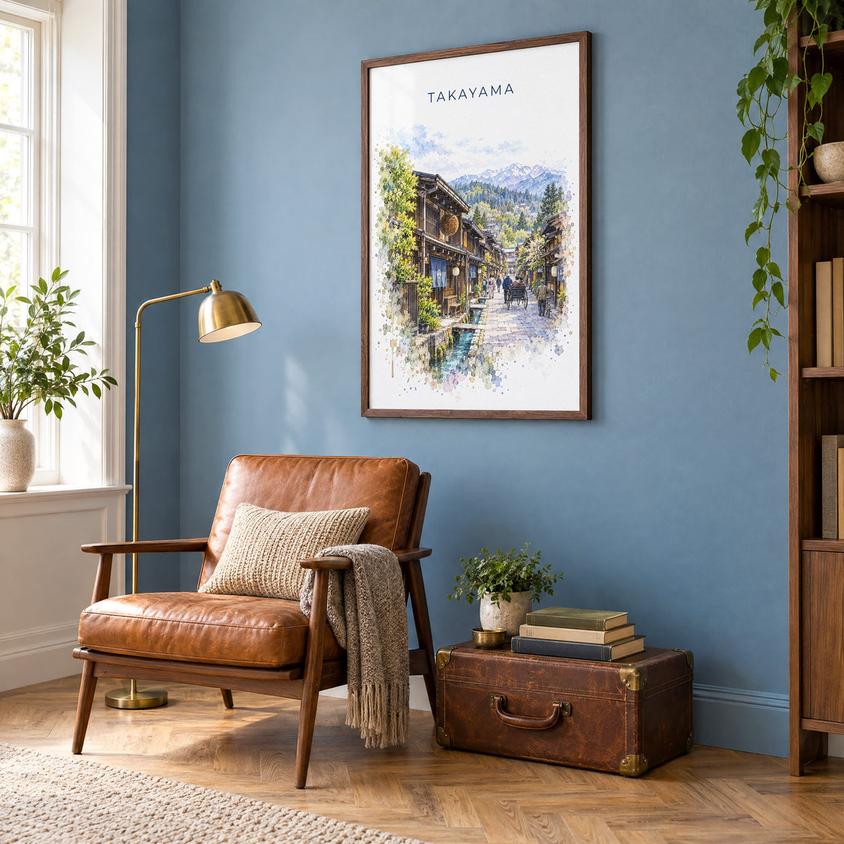 Takayama watercolor print in a walnut frame on a blue wall above a leather armchair in a reading nook