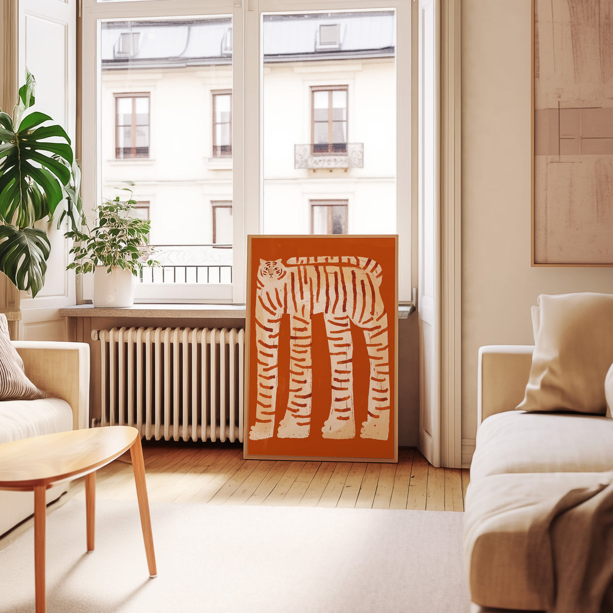 Rust and cream tiger print in an oak frame leaning below tall French windows