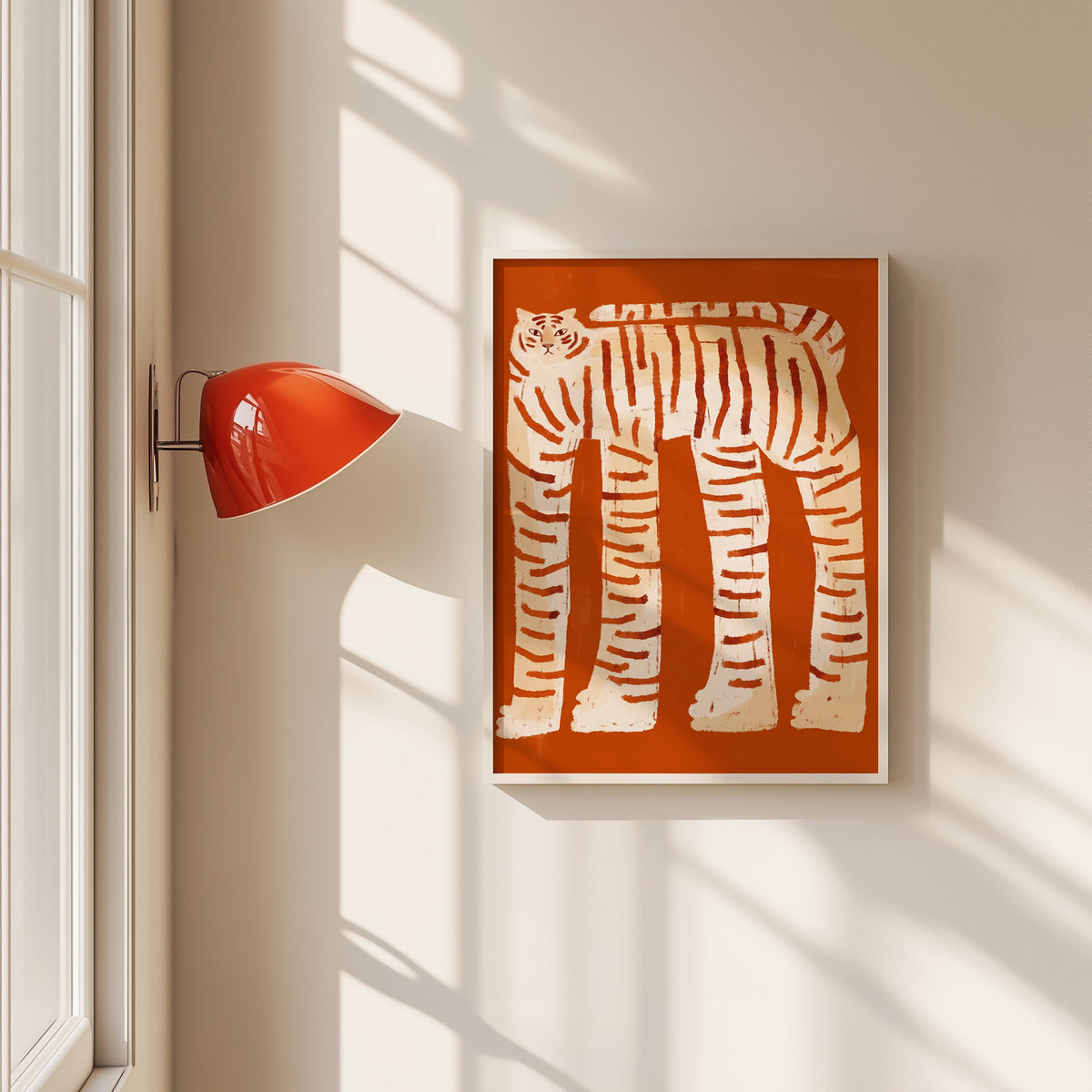 Tall striped tiger print in a white frame beside a red wall sconce
