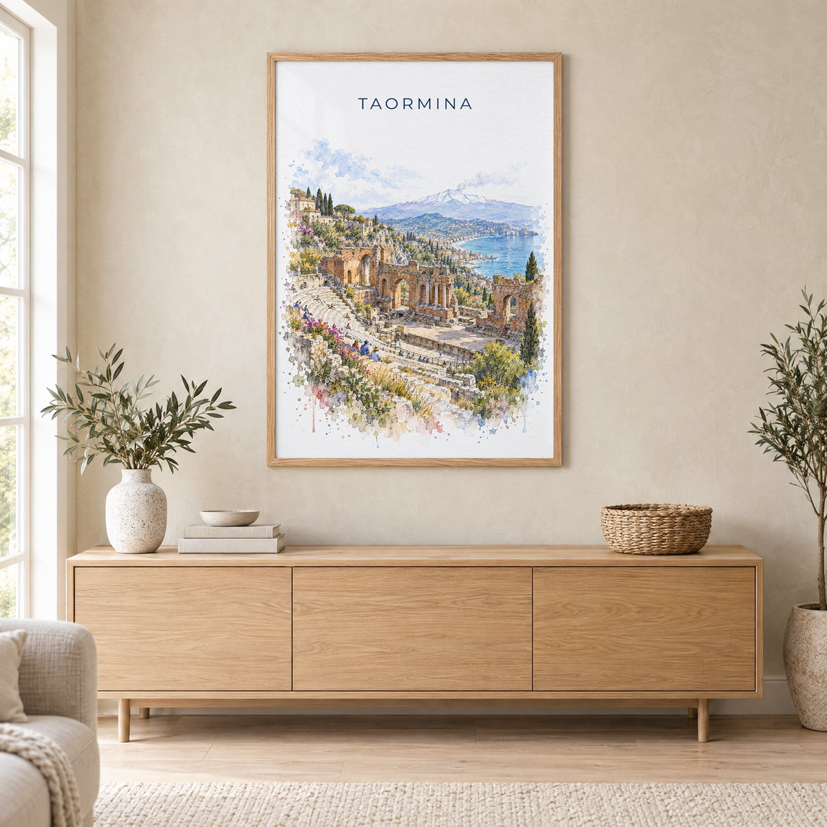 Taormina watercolor print in an oak frame above a light wood sideboard in a Scandinavian living room