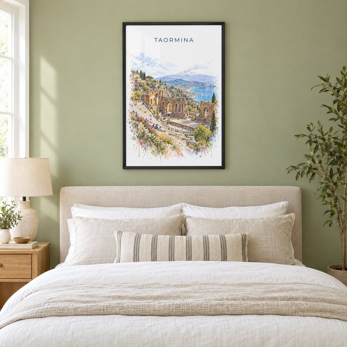 Taormina watercolor print in a black frame above an upholstered headboard in a sage green bedroom