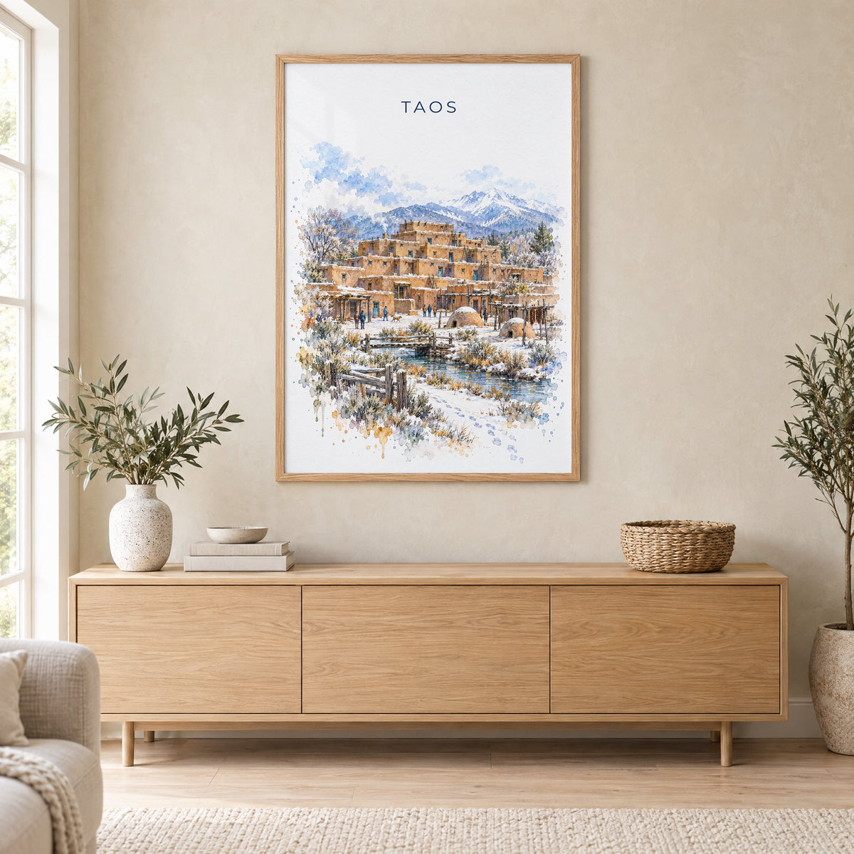 Taos watercolor print in an oak frame above a light wood sideboard in a Scandinavian living room