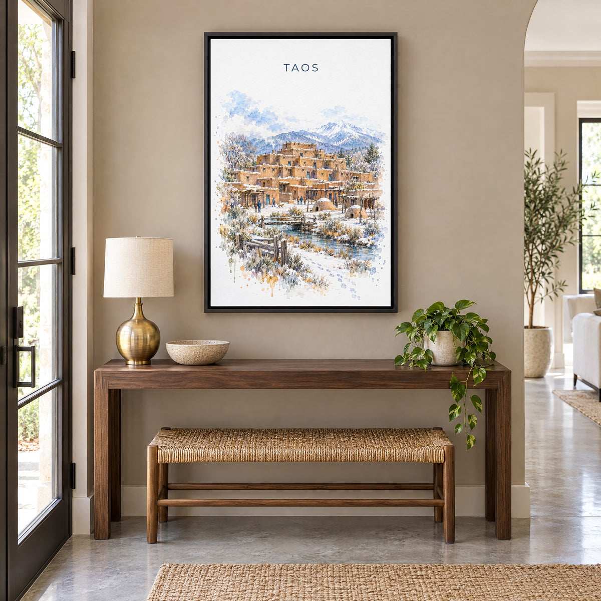 Taos watercolor print as a black floater canvas above a walnut console and woven bench in an entryway