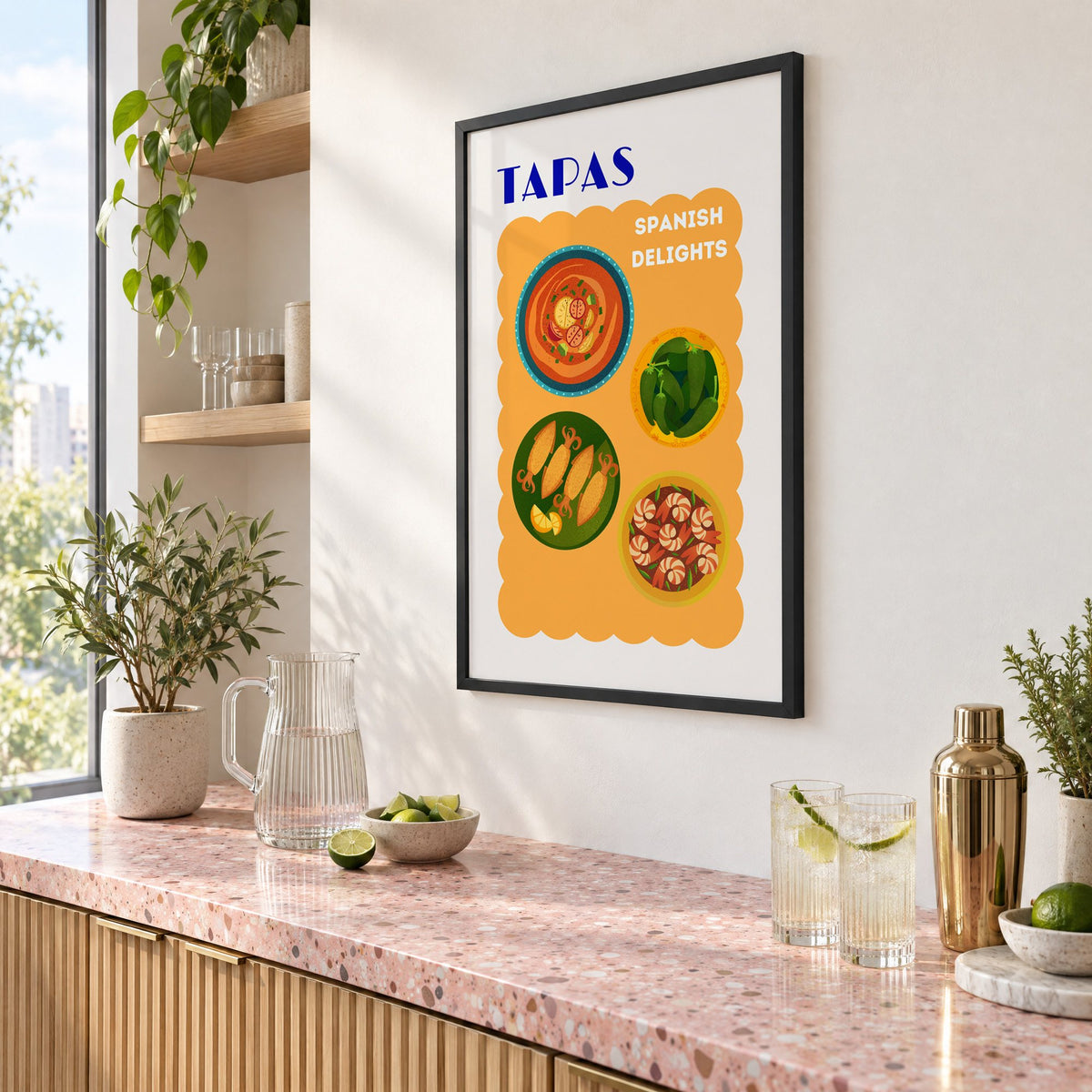 TAPAS Spanish Delights four plates print in a black frame above a pink terrazzo cocktail counter with limes, seen at an angle